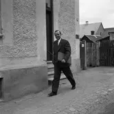 Arboga Tidning, personal.
Man, klädd i kavaj och med en portfölj under armen, utanför tidningshuset.