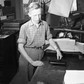 Arboga Tidning, personal och interiör. En ung man arbetar i tryckeriet.