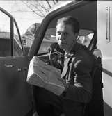 Arboga Tidning, personal. Willy Johansson sitter i bilen. Han ska leverera en bunt tidningar. En del av bilens insida syns i bilden.