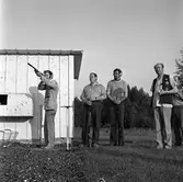 Lerduveskyttar från Arboga tränar i Gyttorp.
Fem män, varav tre med gevär. En av dem skjuter. En annan har hörselkåpor på sig.