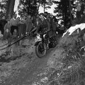 Arbogas Stjärnknutte
Tävling. Man som kör motorcykel i terrräng, publiken står alldeles intill och ser på.