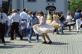 Arbogaträffen
Uppvisning av square dance på ett uppbyggd dansgolv på Stora torget. Kvinnorna har vida kjolar. I bakgrunden syns butik Lyktan och infarten till Västerlånggatan.