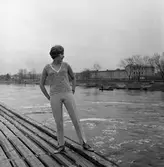 Ateljé Touché. Britt-Marie Utterström visar mode; här iklädd långbyxor och ärmlös jumper.
Bilden är tagen i hamnen. Håvbåtar och Gäddgårdsskolan ses i bakgrunden.
Arbogaån.
Britt-Marie drev ateljén tillsammans med Marianne Rosenkvist.