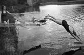 Flickor som badar vid Villagatsbadet. En av dem dyker i Arbogaån.