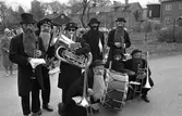 Den här orkestern deltar i firandet av Barnens Dag. Förutom sina instrument bär medlemmarna svarta hattar och långa skägg. I bakgrunden ses tornet på Sankt Nikolai kyrka.
Stående från vänster: Frid, Sune Malmberg, okänd, okänd, möjligen Stig Johnsson
Sittande från vänster: Bror Andersson eller Ingvar Johansson, Pennemo och Torsten Torstling
