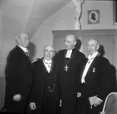 Biskop John Cullberg (tredje mannen från vänster) delar ut medaljer, under ett besök i Sankt Nikolai kyrka.
Herrar i frack.