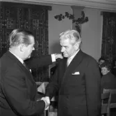 Brandkårens årsfest
Brandchef Gösta Jonsson (till vänster) avtackar Bertil Nordin, deltidsbrandman.
Kvinnan, till höger, är Gudrun Sjökvist. Hon städar hos brandkåren.