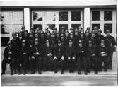 Gruppfotografi av brandmän iklädda uniformer och hjälmar.
Möjligen är de deltidsbrandmän.
Översta raden, från vänster: Harald Larsson (
