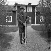 Doktor Bernhard Garsten, Medåker. På grusgången framför sitt hus. Han är klädd i hatt och kavaj. Han håller i en annorlunda grep.