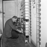 Efter branden på Televerket på Nygatan
Lagningsarbete. En reparatör lyssnar i telefonluren.