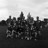 Lions Club ska spela fotboll mot stadsfullmäktige. Här är deras laguppställning inför matchen:
Stående, från vänster: Lars Lutteman, Sten Wahlgren, Arne Öhrman, Verner Liljeborg, Olle Wallström, Helge Carlsson och Folke Petersson.
Sittande, från vänster: Bengt Frendin, Gustav Adolf Persson, Valter Allvin, Nils Röhfors och Olle Berglund.