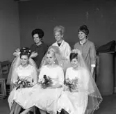 Gesällprov för blivande damfrisörskor. Uppgiften är att ordna en brudklädsel.
Hårfrisörskan längst till vänster är Gisela Stoppel (som arbetat på Salong Topé på Nygatan) och två damfrisörskor från Götlunda.
Brudarna är, från vänster: Gudrun Andersson, Ingemo Björkman och en kvinna från Götlunda.
Alla brudarna har brudklänning, slöja och brudbukett. I håret har de blommor, diadem och brudkrona.