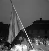 Konung Gustaf Vl Adolf gästar Arboga under sin Eriksgata. Här ses han, på Stora torget, tillsammans med publik och medlemmar i Lottakåren.
För värdskapet svarade stadsfullmäktiges ordförande Jonas Carlsson och kommunalborgmästare Danliel Ekelund. Den organisationskommitté som ansvarade för arrangemangen, hade hos drätselkammaren begärt en summa av 3000 kronor för att täcka kostnaderna vid kungabesöket. Beloppet beviljades. 
Tiden för kungens besök var beräknad till 130 minuter.