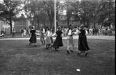 Folkdansare uppträder i Ahllöfsparken i samband med besök från vänorten Hallola.
Publik.
I bakgrunden ses Stadskällaren.