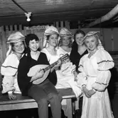 Lokalrevyn 1959
En lutspelare omgiven av vackra damer
Från vänster: Mona Jansson, Berit Österberg, okänd, okänd, okänd och Ann-Sofie Zetterberg.
Bilden är tagen i källaren under Folkan/Medborgarhuset