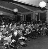 Publiken som ser på Luciarevyn (se bild 07983). Eleverna är födda 1943 - 1944
Personer som är igenkända: Jan Fälth, Göran Munter, Karl-Ove Johansson, Kühne, Lars-Göran Jansson, Olle Åkerström, Bertil Persson, Börje Blomkvist, Göran Holmkvist, Göran Matson och Inge Larsson