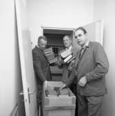 Polisen packar och flyttar från Rådhuset.
Från vänster: Stig Söderling, Sigurd Granberg och Harry Hellenberg.
Tre män packar tjocka böcker i en flyttlåda.