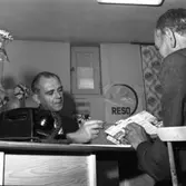 Resebyrån Reso i nya lokaler.
En man besöker resebyrån och får titta i broschyrer. I förgrunden syns en telefon.