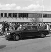 550-årsminnet av Sveriges första riksdag firas i Arboga. Kungaparet (som just stigit in i bilen) lämnar platsen för den gemensamma lunchen. I höjd med bilens vindruta, ses statsminister Olof Palme. Bakom honom står Tanzanias presient, Julius Nyerere. De, och övriga politiker, inväntar sina transporter.