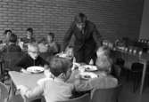 Skolchef Per Thorstensson visar skolan för barn från lekskolan. Ett besök i skolbespisningen ingår.
Barn som sitter och äter vid två bord. De har mjölk i glasen.