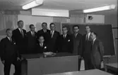 TBV håller kurs i nationalekonomi. Den fjärde mannen, från höger, är Anders Högfeldt. Tio män i kostym och slips samlade i ett klassrum. En man sitter bakom katedern med en uppslagen bok. I bakgrunden finns en svart tavla. Lysrörslampor i taket. Det är lågt i takhöjd och ger en känsla av att de befinner sig i en källarlokal.
Tjänstemännens BildningsVerksamhet