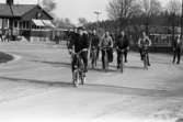 Arbetsdagen är slut på CVA, Centrala Verkstaden Arboga. Ingenjörer och verkstadsarbetare är på väg hem på sina cyklar. I bakgrunden ses 