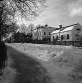Östra Nygatan. Köpingstullen, Glasbruksvillan och ett hus till. Vinter och snö.
Bergmansparken till vänster.