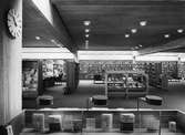 Arboga Stadsbibliotek, interiör. Fotografen har entrén bakom ryggen. Bilden är tagen ut i stora bokhallen. Bokhyllor med böcker, från golv till tak.