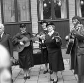 Frälsningsarmén spelar på höstmarknaden. Två kvinnor spelar gitarr, en spelar dragspel och en kvinna sjunger.