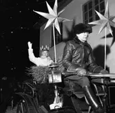 Gustav Jansson, på kuskbocken, kör årets Lucia, Ingrid Zettergren. 
Ingrid tyckte att detta var en fantastisk upplevelse men hon frös. Det var -13 grader den kvällen.
Hon har batteriljus i håret och en hökärve i knät. 
Vagnen är pyntad med julstjärnor och Gustav har en vagnslykta intill sig.