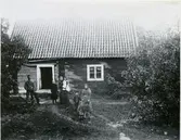 Lillhärad sn, Västerås.
Skräddartorp. Familj stående utanför bostaden. 1900-1910.