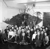 Scouternas Vargungar samlade för gruppfotografering. Två unga kvinnor står längst bak. Pojkarna har sjal om halsen.