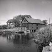 Kastmanska gården i Figeholm. Bostadshus och ekonomibyggnad samt vattendrag med eka.