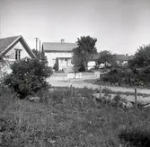 Vy från Figeholm, bostadshus med träpanel och sadeltak.