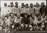 Porträttbild av fotbollslaget Järnvägens Idrotssförening Oxelösund som tog silver i Svenska Järnvägsförbundets B-cup i Göteborg 1975. Stående från vänster: Kjell Söderberg, Ola Forsberg, Lars Eriksson, Christer Arewång, Stefan Engstrand, Jan-Erik Johansson, Ove Augustsson och lagledaren Albert Gustavsson. Knästående från vänster: Inge Johansson, Sverre Schröder, Lennarth Fällgren, Leif Lindskog, Lars Gustavsson, Kurt Carlsson och Kaj Persson.