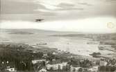 Vykort över hamnen i Sundsvall och ett flygplan i luften.