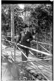 Hålahult sanatorium, exteriör, en man på en träbro i skogen klädd i kostym och hatt cigarr i handen, underläkare N.G.K. Lewenhagen 1/10 - 31/10 1916?