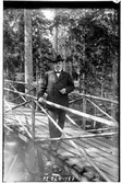 Hålahult sanatorium, exteriör, en man på en träbro i skogen klädd i kostym och hatt cigarr i handen, underläkare N.G.K. Lewenhagen 1/10 - 31/10 1916?