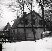 Mangårdsbyggnad i Runtorp, med mansardtak, träpanel och Tympanon.