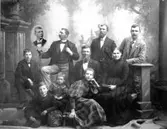 Ateljéporträtt av familjen Gustavsson, Varberg. Fadern var timmerman och ägde under åren 1866-1899 fastighet nr 124 i kv Timmermannen. I mitten sitter han, Johan Berndt, med makan Anna Mathilda (f. Johanssdotter, Reftele) och framför dem sitter de minsta barnen fr. v. Gunnar, Robert och Agnes. Av åldrarna att döma är det troligen sonen Gustaf Wilhelm som sitter på stolen och den äldste, kustroddaren Johan Anton August, som står mellan föräldrarna. De två andra sönerna hette Carl Viktor och Anders Bernhard. Det infällda porträttet visar en son som var död.