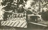 Vykort med motiv av en utsmyckad lastbil med sex stycken kvinnor på flaket. Enligt texten på baksidan: Barnens dag i Sundsvall  07 september 1930
