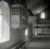 Interiör av Döderhults kyrka. Långhuset med burspråk och  kyrkbänkar.