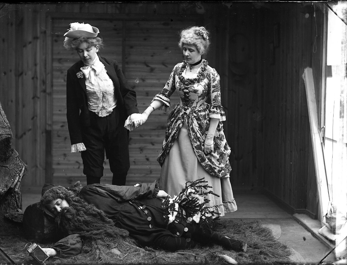 Calla Helena Sundbeck, Historical Tablet. Two women in mixed attire and 1700s wear hold each other in hand and look down at a person lying on the floor with long dark hair and large beard - like a hermit. The woman on the right is probably Mrs Sörlander.