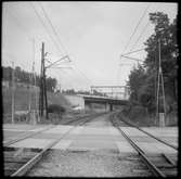 Plankorsning nära Storängens station, Saltsjöbanan. Vattenverksvägen korsar järnvägsspåret vid plankorsningen och bilbron är en del av Saltsjöbadsleden.