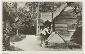 Vykort med motiv från Skansen. Oktorpsgården. Halland. Man vid brunn.