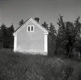 Gaveln på ett mindre bostadshus med putsad fasad.