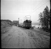 Vid grustaget ses Nordmark - Klarälvens Järnväg, NKlJ ellok 37 med fyra godsvagnar.