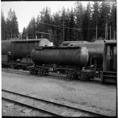 Mitt i bild ses godsvagn lastad med cistern innehållande svavelsyra. Godsvagnen till vänster Nora Bergslags Järnväg, NBsJ 502003 lastad med cistern för frätande vätska.