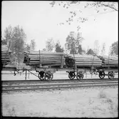 Godsvagnar med timmer.