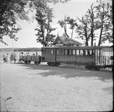 Resande vid ångbåtsstationen i Mariefred där Museijärnvägen, Östra Södermanlands Järnväg, ÖSlJ Helsingborg - Råå - Ramlösa Järnväg, HRRRJ personvagn 7 och Nättraby - Alnaryd - Älmeboda Järnväg, NAEJ godsvagn 70 står vid ändspåret.